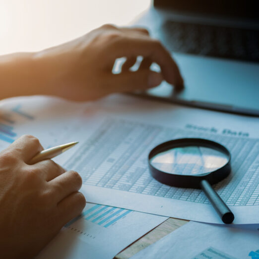 Businessman looking through a magnifying glass to documents. Business assessment and audit. Magnifying glass on a financial report. Close-up Of Businessperson Checking Bills With Magnifying Glass.Concept of search.